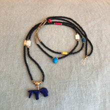 Charger l'image dans la galerie, Sautoir en perles de rocaille noires, perles hématites dorées et petites perles semi précieuses colorées. Pendentif petit animal cheval indigo.