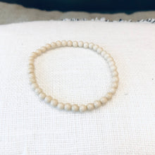Charger l'image dans la galerie, bracelet pierre de rivière blanche sur coussin tissé blanc