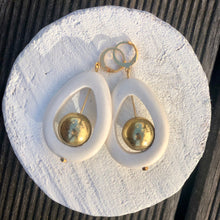 Charger l'image dans la galerie, Nature morte sur rondin de bois d'une paire de boucles d'oreille en bois blanc ajouré avec perle ronde en laiton doré avec attache petite créole or