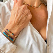 Charger l'image dans la galerie, Bracelets surfeur turquoise et violet et un bracelet miyuki perles rouges et turquoises, collier miyuki perles multicolores et chemise blanche ouverte sur décolleté