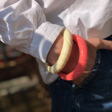 Charger l'image dans la galerie, 2 bracelets en résine style vintage corail et crème sur poignet chemise blanche et main dans une poche de jean