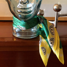 Charger l'image dans la galerie, Petit carré de soie vert vif avec un liseret jaune et d'yeux stylisés noué autour du cou d'un tête moulée en verre