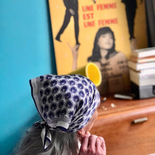 Charger l'image dans la galerie, carré de soie noué sur la tête façon pirate fond mur turquoise et affiche de cinéma