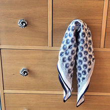 Charger l'image dans la galerie, petit carré de soie fleurs bleues accroché à un bouton de tiroir d'une commande en bois clair