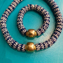 Charger l'image dans la galerie, un collier et un bracelet en perles céramiques bleues du Ghana sur un fond turquoise