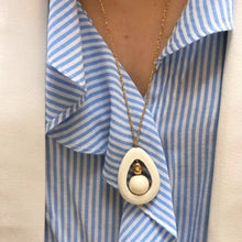 Charger l'image dans la galerie, Gros plan sur sautoir en bois blanc ajouré et perles bois et plaqué or sur fil d'or. Décolleté femme avec chemise rayée et veste blanche.