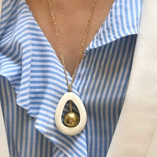 Charger l'image dans la galerie, Gros plan sur sautoir en bois blanc ajouré et perle laiton sur fil d'or . Décolleté femme avec chemise rayée et veste blanche.