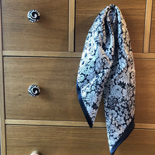 Charger l'image dans la galerie, petit carré de soie fleurs noires et blanches accroché à un bouton de tiroir d'une commode en bois clair