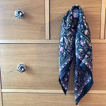 Charger l'image dans la galerie, petit carré de soie petites fleurs sur fond noir accroché à un bouton de tiroir d'une commode en bois clair