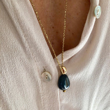 Charger l'image dans la galerie, sautoir talisman bohème sur fil d'or avec perle pendentif verre noire et perle galet plaquée or sur décolleté chemise blanche