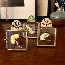 Charger l&#39;image dans la galerie, 3 mini cadres à poser en laiton doré et émail peint de 3 couleurs différentes présentés avec composition de petites fleurs sechées
