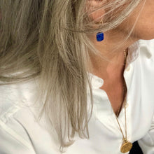 Charger l&#39;image dans la galerie, Gros plan sur un profil femme au cheveux longs poivre et sel et à l&#39;oreille boucle d&#39;oreilles avec une perle rectangulaire facettée en Lapis Lazuli 

