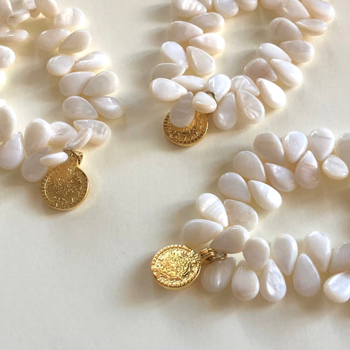 3 bracelets élastiques en perles goutte de nacre blanche et une breloque pendentif or