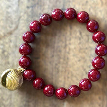 Charger l&#39;image dans la galerie, Bracelet en perles rondes et lisses bordeaux avec une breloque africaine en laiton doré
