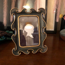 Charger l&#39;image dans la galerie, cadre photo rococo bohème noir et or posé sur un buffet en bois
