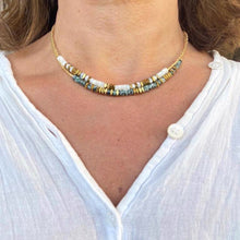 Charger l&#39;image dans la galerie, 2 colliers surfeurs, un crème et un vert clair avec ^perlles miyuki or sur un cou de femme bronzée en chemise blanche
