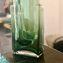 Charger l&#39;image dans la galerie, Détail de la base épaisse  d&#39;un vase en verre vert sur un comptoir à carreau de zéligs noirs
