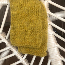 Charger l&#39;image dans la galerie, Mitaines en alpaga tricotées main jaune safran sur un fauteuil en osier blanc
