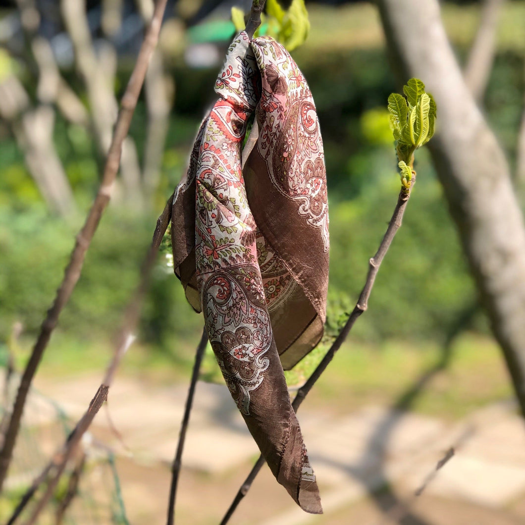mini carré de soie à motifs cachemire rose et marron clair noué sur branche nature