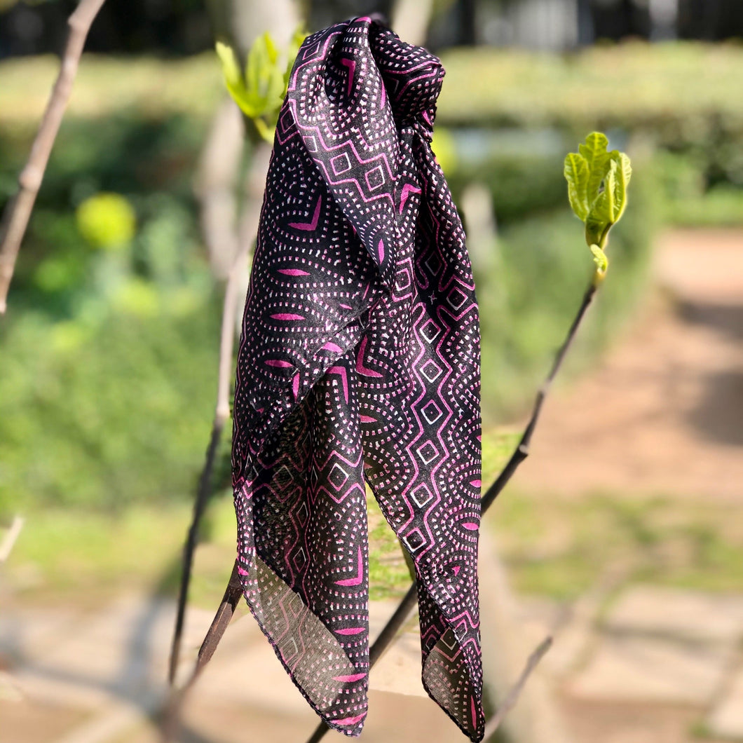 mini carré de soie à motifs fuchsia et noir noué sur branche nature