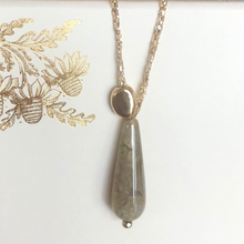 Charger l&#39;image dans la galerie, Perle de verre forme goutte grise sur fil d&#39;or et perle de galet plaquée or
