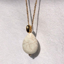 Charger l&#39;image dans la galerie, Sautoir talisman bohème composé d&#39;une perle magnésite forme goutte et d&#39;une perle galet plaqué or sur fil doré. Fond blanc.
