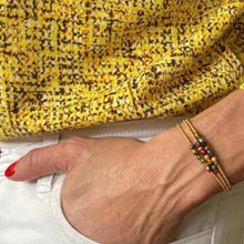 Charger l&#39;image dans la galerie, 3 bracelets miyuki précieux ambre et rouge sur un poignet ,main dans la poche jean blanc et top impression jaune
